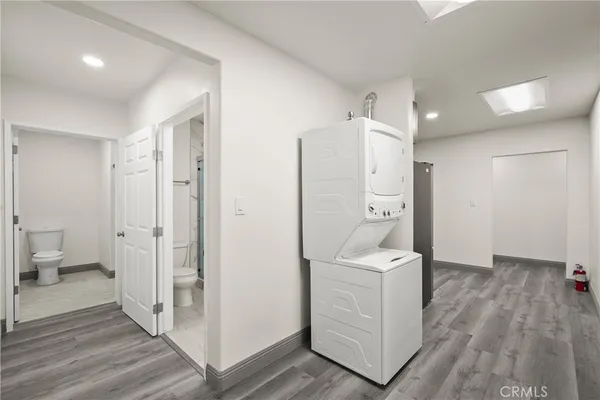 a view of a hallway with bathroom and wooden floor