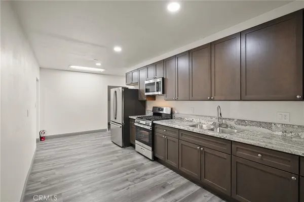 a kitchen with stainless steel appliances granite countertop a sink stove and refrigerator