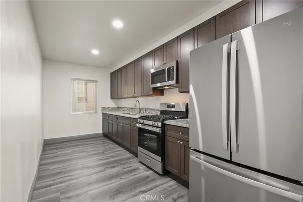 a kitchen with stainless steel appliances a refrigerator sink and stove