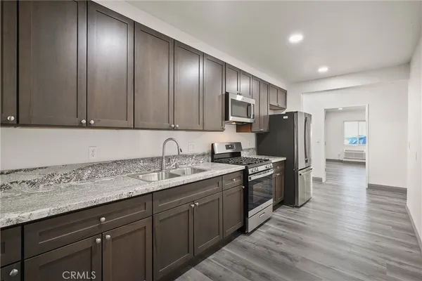 a kitchen with stainless steel appliances granite countertop a sink stove and refrigerator