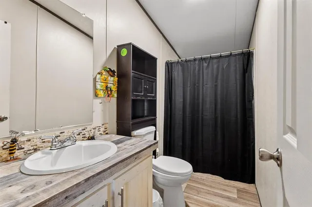 a bathroom with a sink vanity mirror and toilet