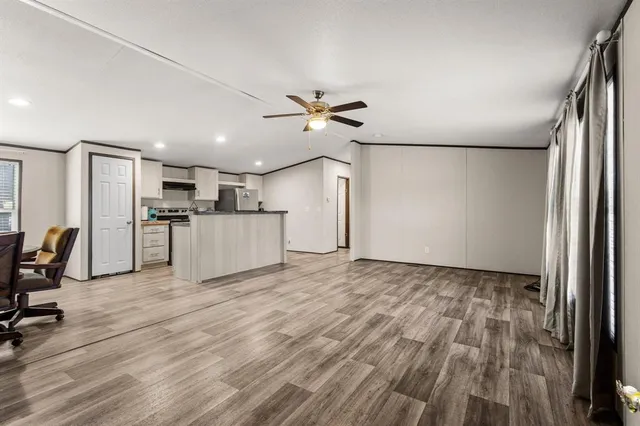 a view of a kitchen with a refrigerator a microwave and a ceiling fan