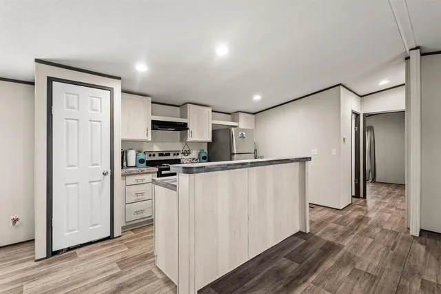 a kitchen with stainless steel appliances granite countertop a refrigerator and a stove top oven