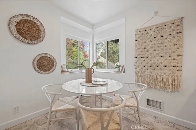 a dining room with chandelier fan and wooden floor