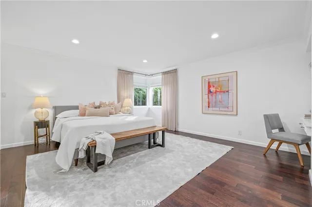 a spacious bedroom with a bed and a chair