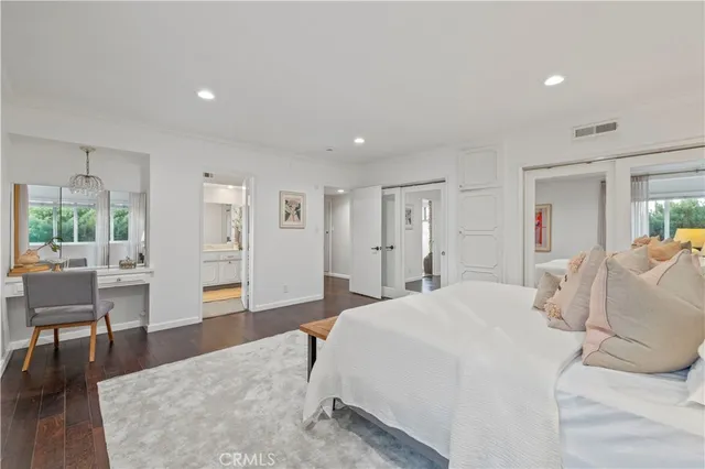 a spacious bedroom with a bed a table and chair