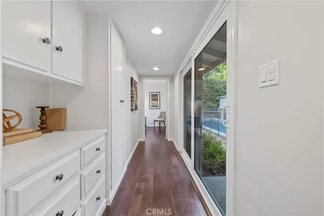 a view of a hallway with wooden floor and closet