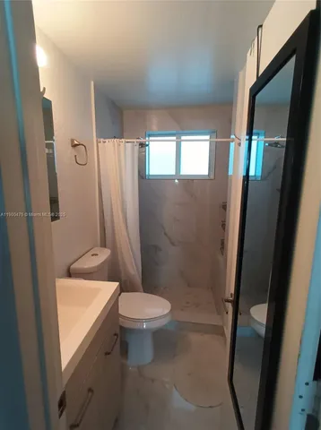 a bathroom with a sink a toilet window and a shower