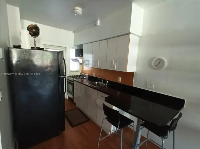 a kitchen with a refrigerator and a stove top oven