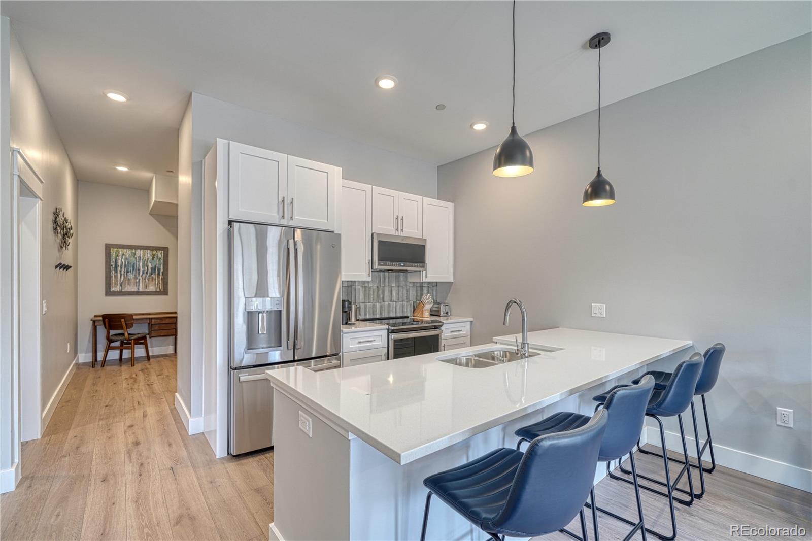 136 Old Stage Road, Unit 1B Salida, CO 81201 - Photo 5 of 24 a kitchen with stainless steel appliances kitchen island granite countertop a kitchen island hardwood floor sink and stove