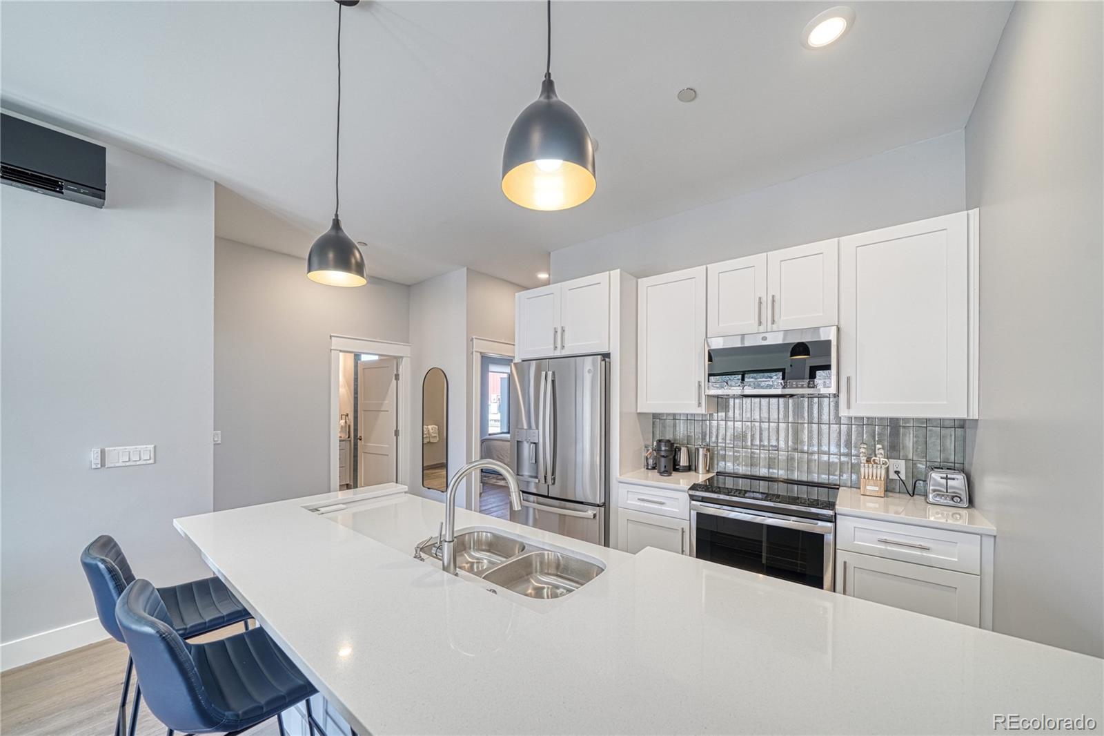 136 Old Stage Road, Unit 1B Salida, CO 81201 - Photo 9 of 24 a kitchen with stainless steel appliances kitchen island granite countertop a sink and refrigerator