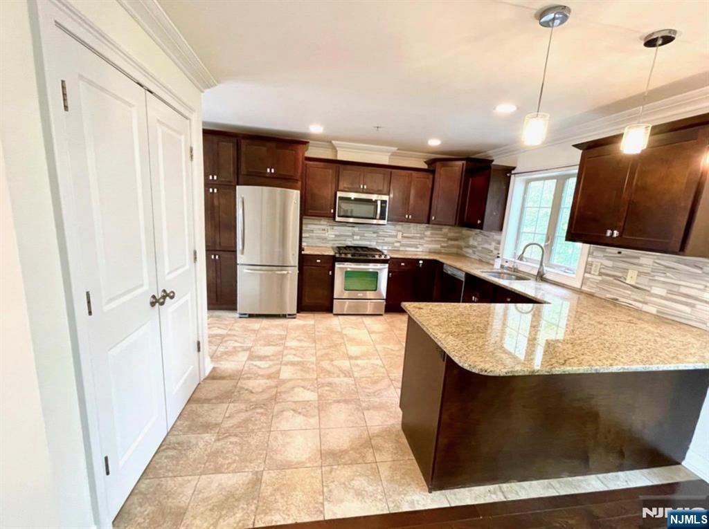 1625 Paterson Plank Road, Unit 18 Secaucus, NJ 07094 - Photo 8 of 23 a large kitchen with kitchen island a stove a refrigerator a sink dishwasher and wooden cabinets with wooden floor