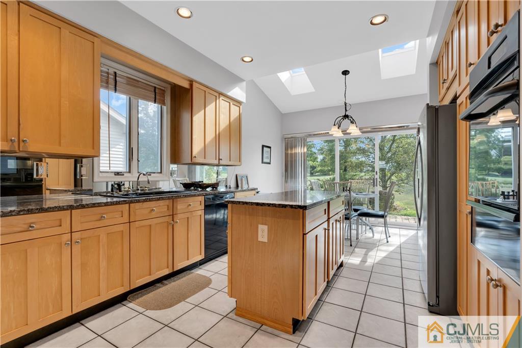 45 Harwood Road Monroe Township, NJ 08831 - Photo 15 of 35 a kitchen with granite countertop a stove a sink and a refrigerator