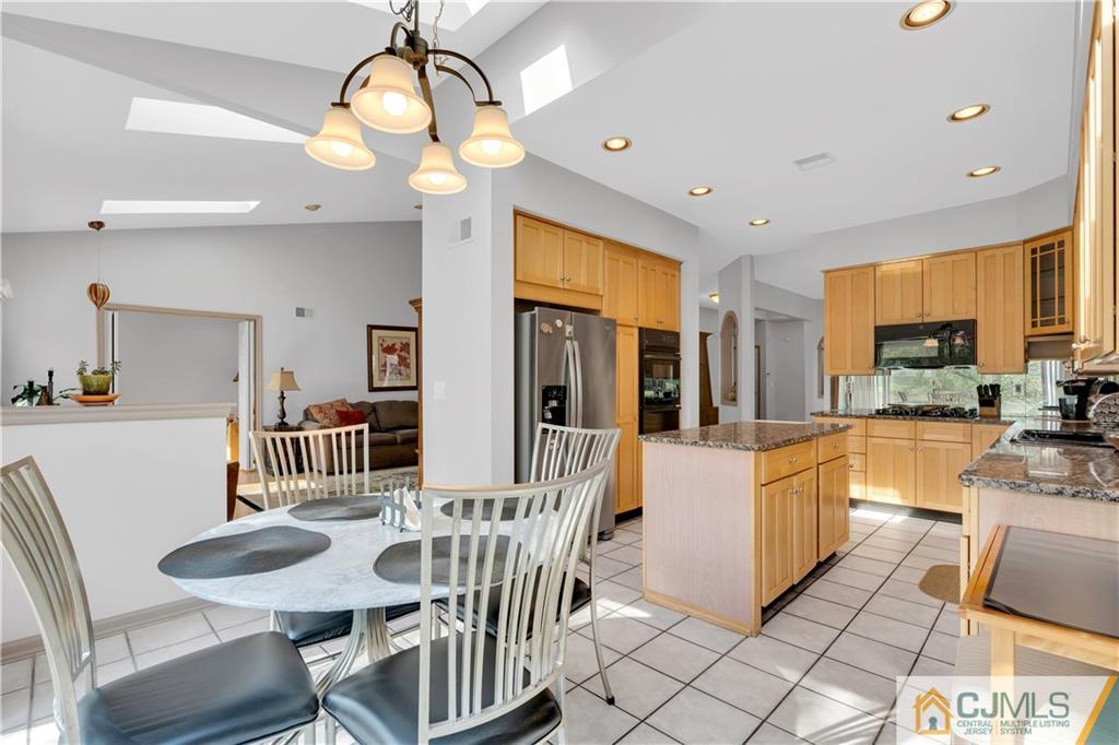 45 Harwood Road Monroe Township, NJ 08831 - Photo 16 of 35 a dining room with wooden floor a chandelier a wooden table and chairs