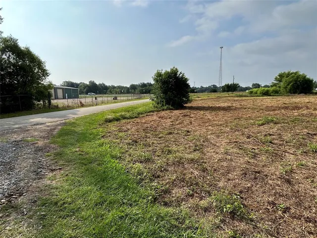 a view of a field with trees in the background