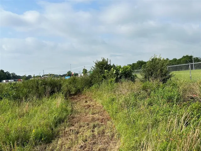 a view of a green field with wooden fence