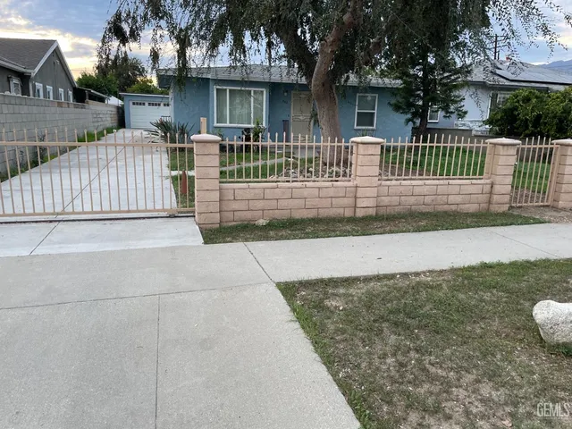 a view of a house with a small yard and wooden fence