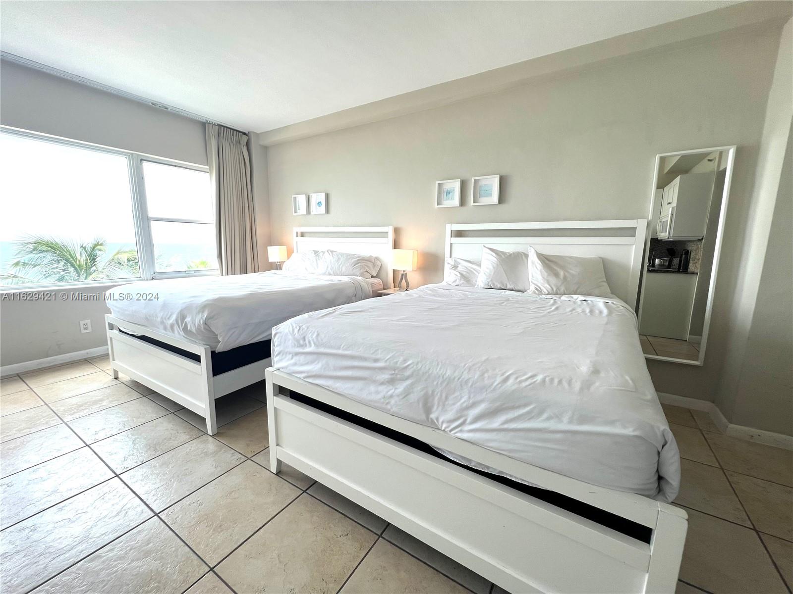 6345 Collins Avenue, Unit 635 Miami Beach, FL 33141 - Photo 5 of 28 a spacious bedroom with a bed and a large window