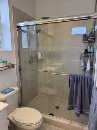 a bathroom with a shower a toilet and a sink