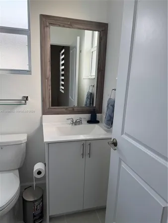 a bathroom with a toilet sink and mirror
