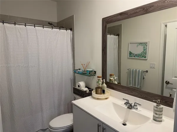a bathroom with a sink a toilet and shower curtain