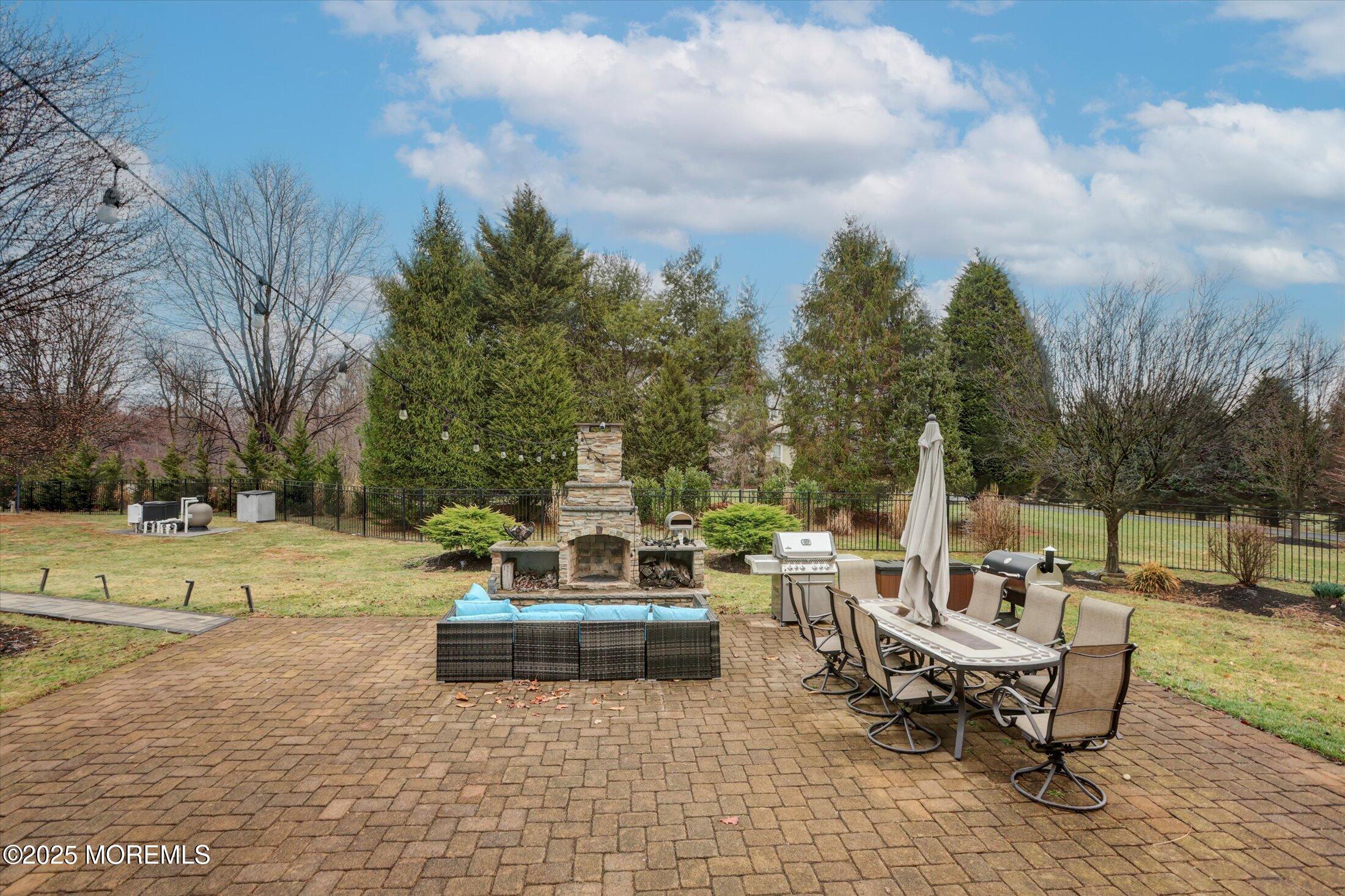 330 Randolph Road Freehold, NJ 07728 - Photo 34 of 63 a view of a patio with dining table and chairs with a fire pit
