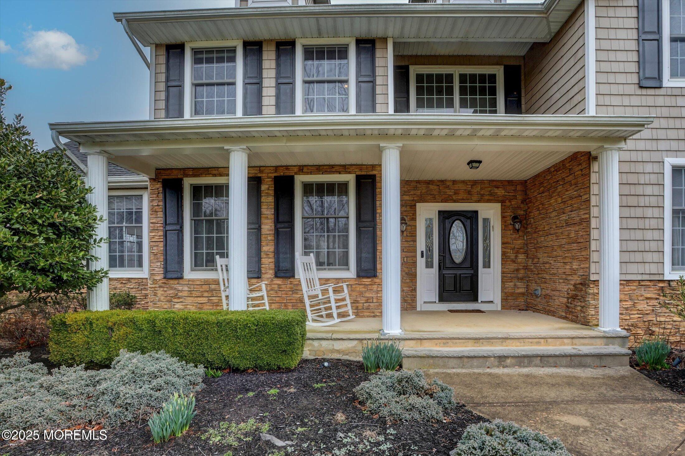 330 Randolph Road Freehold, NJ 07728 - Photo 5 of 63 front view of a brick house with a yard and plants