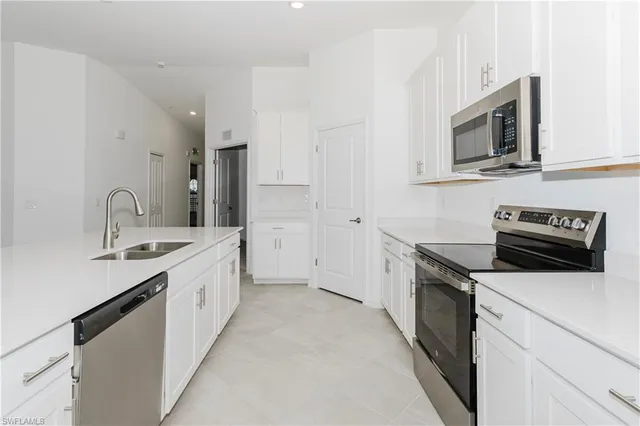 a kitchen with stainless steel appliances a stove microwave and sink