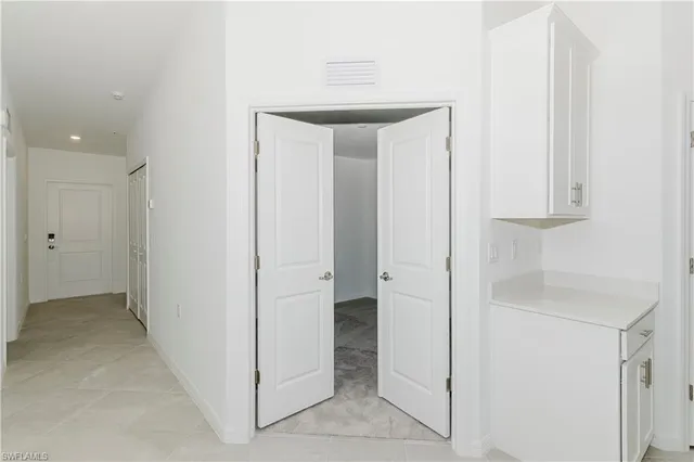 a view of a hallway with closet and a bathroom