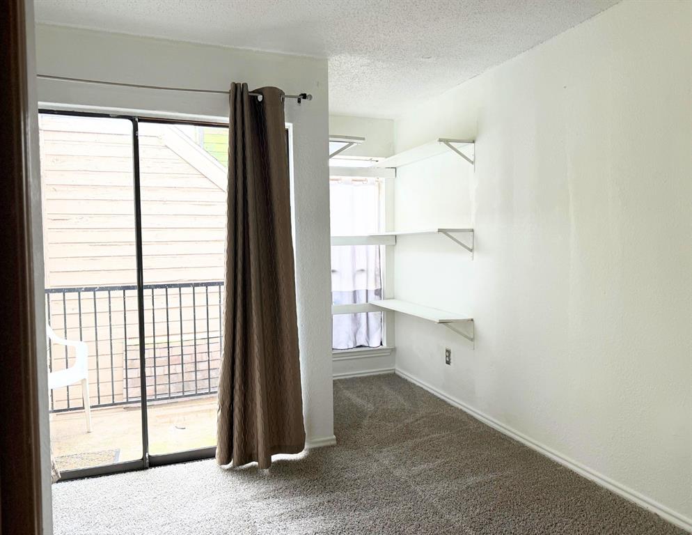 9803 Walnut Street, Unit 308 Dallas, TX 75243 - Photo 8 of 13 Spare room featuring plenty of natural light, a textured ceiling, baseboards, and carpet floors