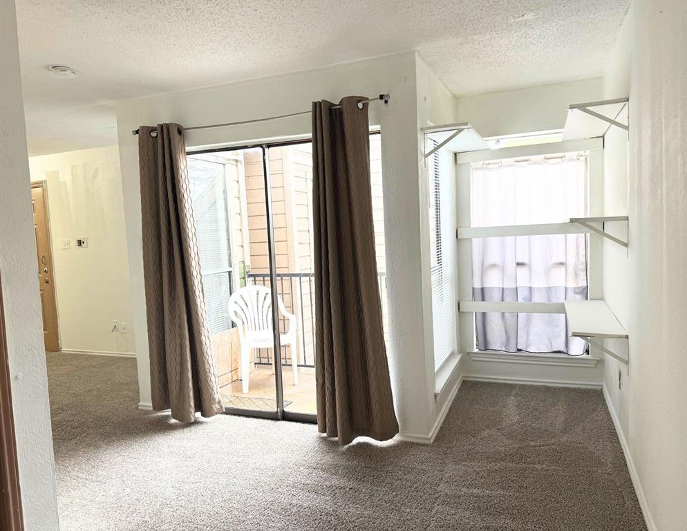 9803 Walnut Street, Unit 308 Dallas, TX 75243 - Photo 9 of 13 Hall featuring baseboards, a textured ceiling, and carpet