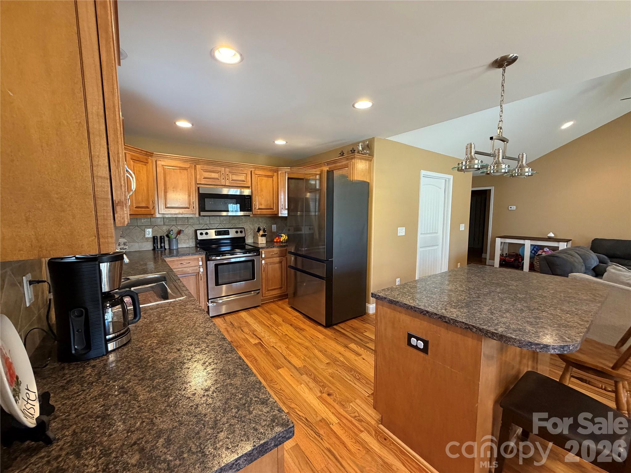 510 East Carpenter Street Maiden, NC 28650 - Photo 6 of 20 a kitchen with stainless steel appliances granite countertop a refrigerator a stove a sink a dining table and chairs