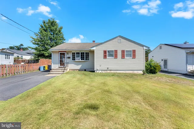 a front view of a house with a yard and trees