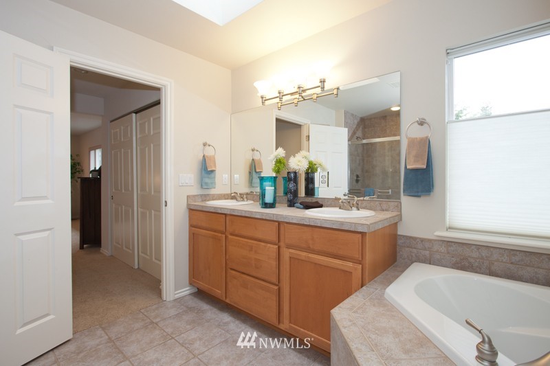 4806 Northeast 20th Place Renton, WA 98059 - Photo 12 of 17 a bathroom with a tub sink and mirror