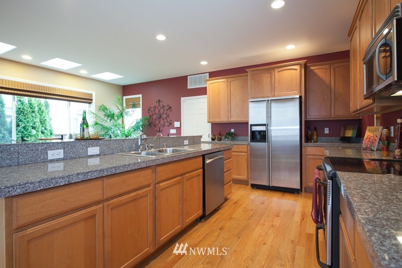 4806 Northeast 20th Place Renton, WA 98059 - Photo 5 of 17 a kitchen with stainless steel appliances granite countertop a refrigerator a sink and a stove
