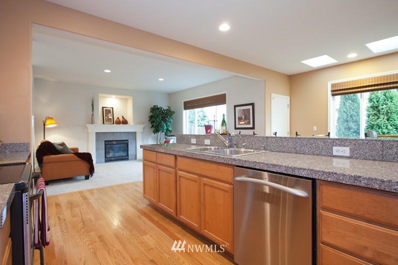 4806 Northeast 20th Place Renton, WA 98059 - Photo 7 of 17 a large living room with granite countertop furniture a fireplace and a large window