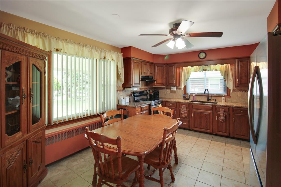 1256 Ridge Avenue Whitehall, PA 18052 - Photo 17 of 43 A well-appointed kitchen features rich wooden cabinetry, granite countertops, and a cozy eat-in area.