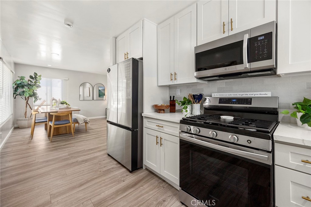 11629 185th Street Artesia, CA 90701 - Photo 8 of 20 a kitchen with stainless steel appliances a stove microwave and cabinets