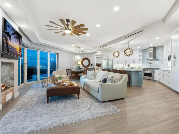 a living room with furniture kitchen view and a large window