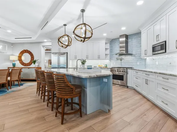 a kitchen with stainless steel appliances granite countertop a sink and stove with wooden floor