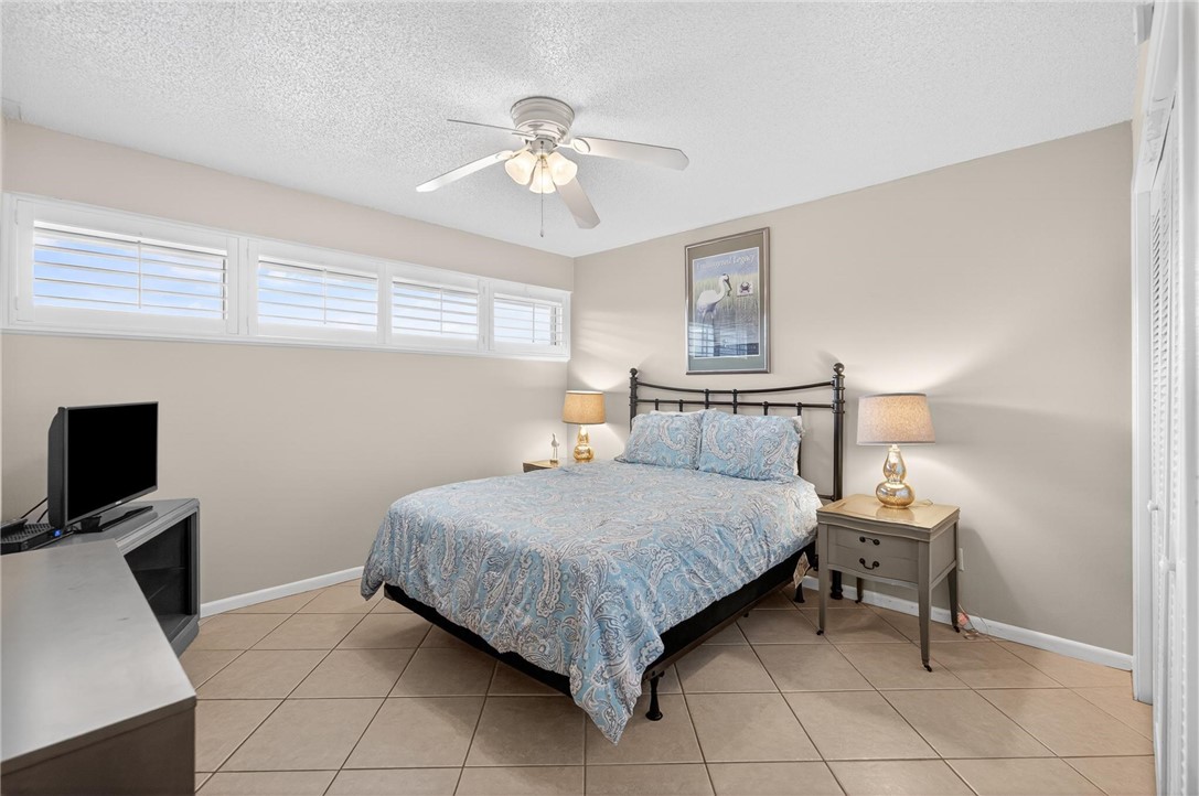 14810 Windward Drive, Unit 402 Corpus Christi, TX 78418 - Photo 16 of 39 a bedroom with a bed and furniture