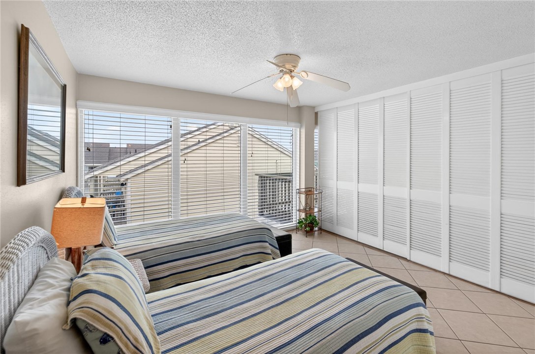 14810 Windward Drive, Unit 402 Corpus Christi, TX 78418 - Photo 22 of 39 a bedroom with a bed and a chandelier
