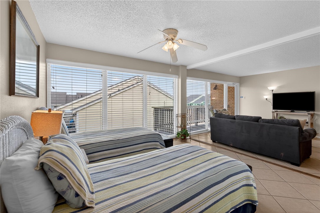 14810 Windward Drive, Unit 402 Corpus Christi, TX 78418 - Photo 23 of 39 a bedroom with a bed and glass windows