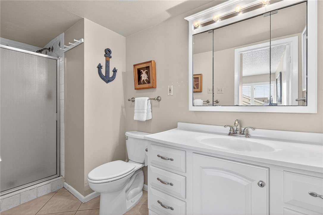 14810 Windward Drive, Unit 402 Corpus Christi, TX 78418 - Photo 24 of 39 a bathroom with a sink toilet and vanity