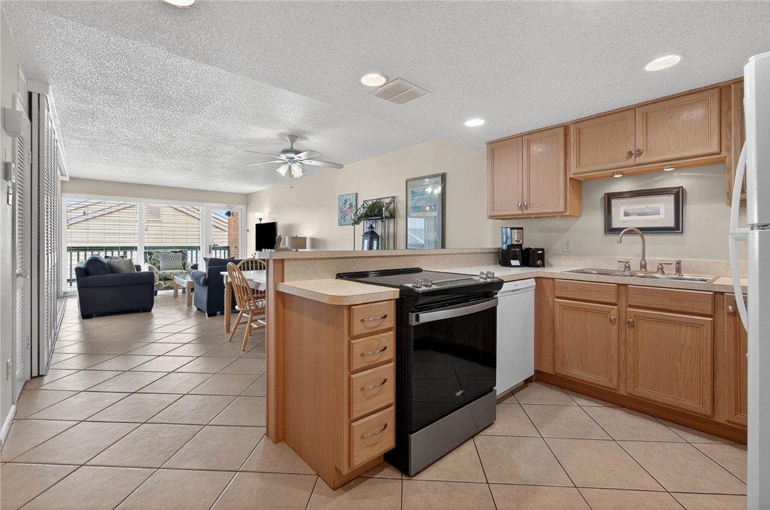 14810 Windward Drive, Unit 402 Corpus Christi, TX 78418 - Photo 4 of 39 a kitchen with a sink a counter top space appliances and cabinets