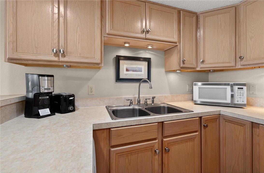 14810 Windward Drive, Unit 402 Corpus Christi, TX 78418 - Photo 6 of 39 a kitchen with white cabinets and a sink