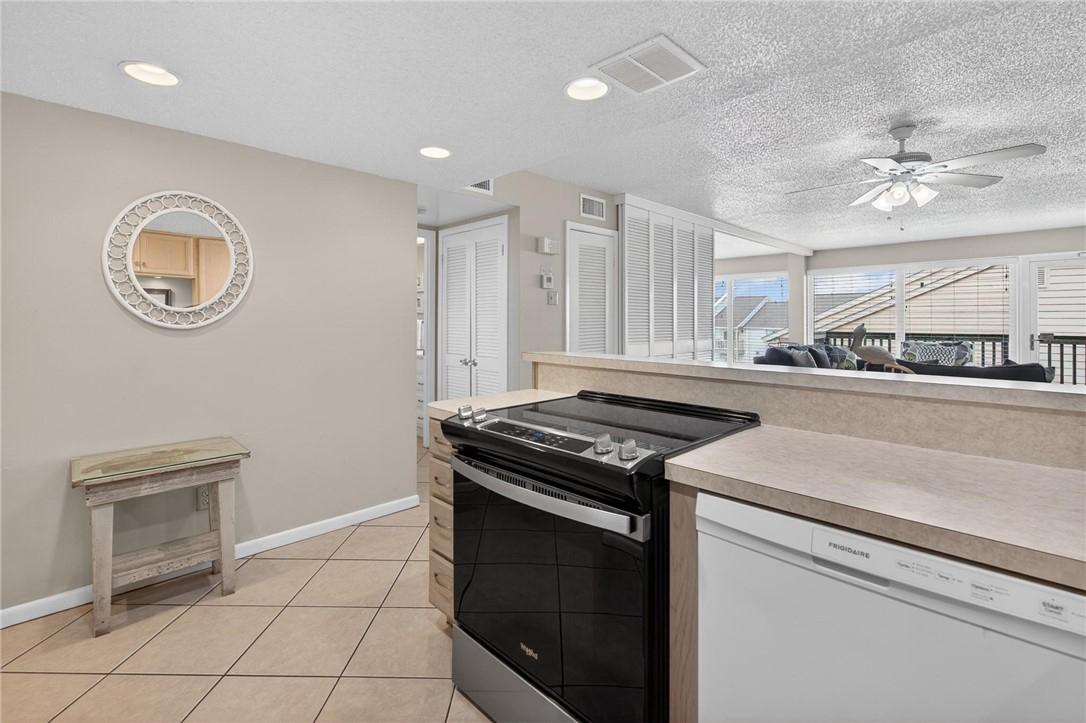 14810 Windward Drive, Unit 402 Corpus Christi, TX 78418 - Photo 7 of 39 a kitchen with a stove and a microwave