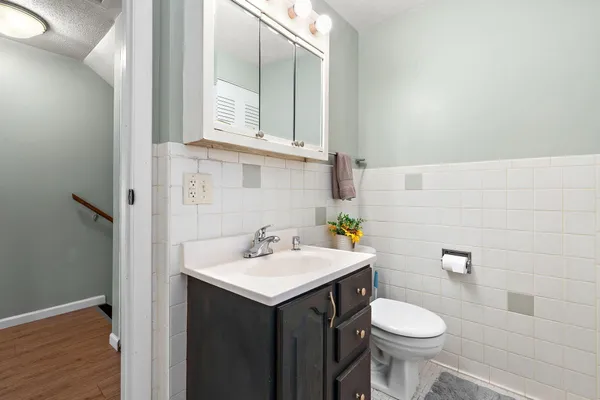 a bathroom with a sink mirror and toilet
