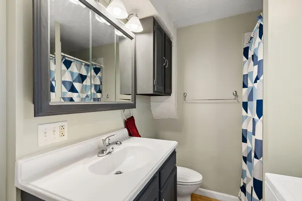 a bathroom with a sink and a mirror with toilet