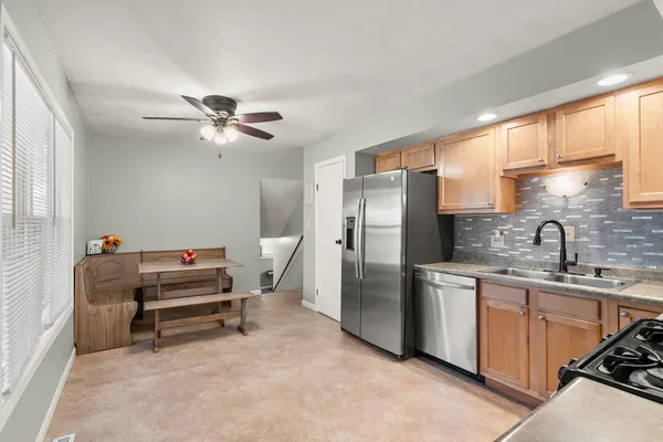 a kitchen with stainless steel appliances kitchen island granite countertop a sink stove and refrigerator